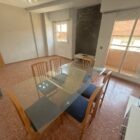 Salón grande y luminoso con mesa y balcón